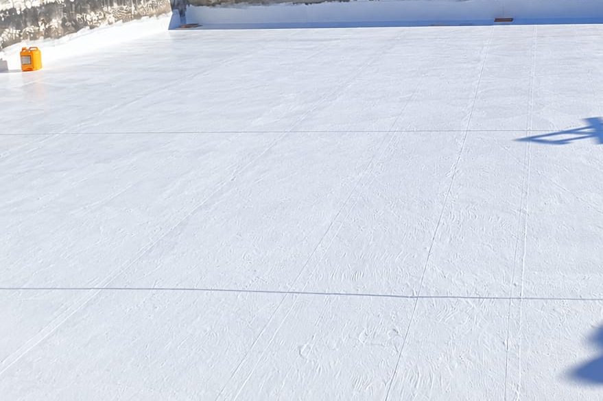 Azotea terminada con impermeabilización blanca y parapetos