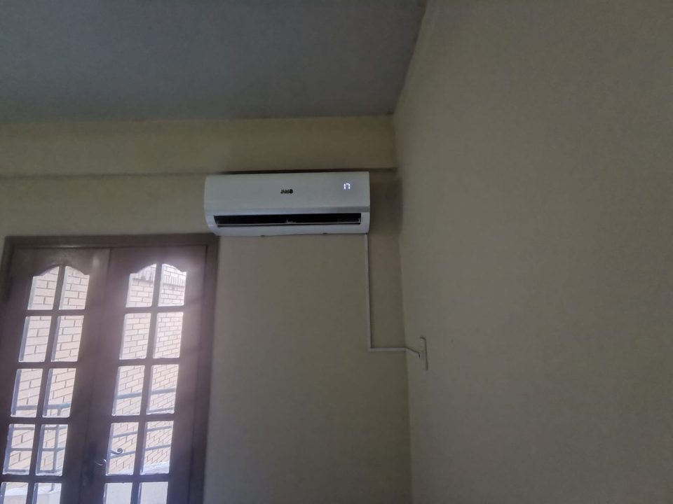 Equipo split instalado en la pared sobre una puerta ventana, con la cañería en canaleta