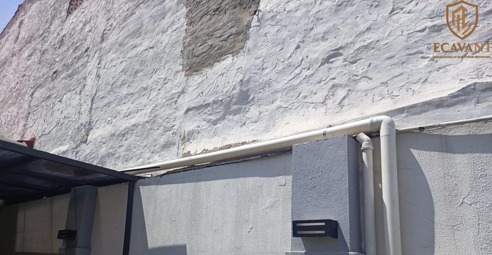 Caño de PVC para cableado recorriendo la parte alta de un muro exterior, fijado con abrazaderas
