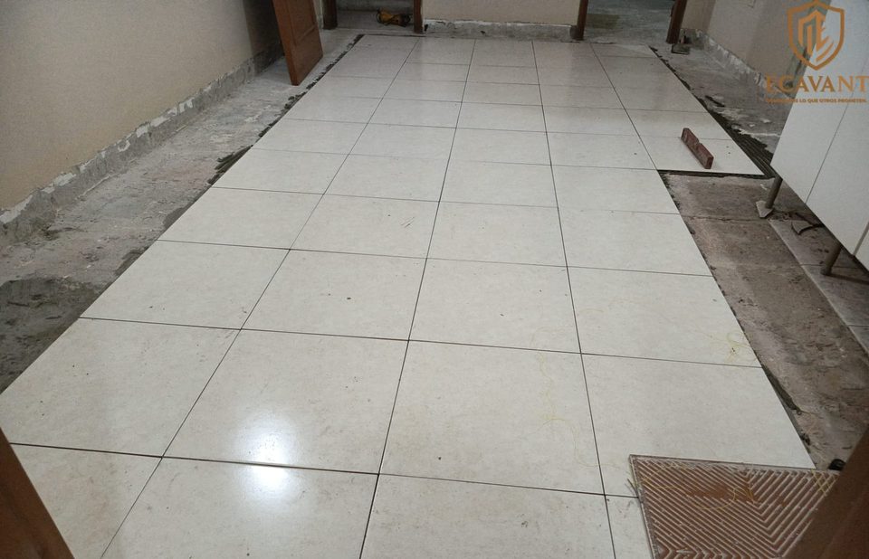 Colocación de piso cerámico nuevo en una cocina, durante la obra