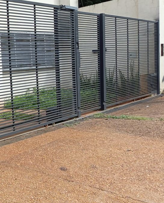 Portón nuevo de varillas metálicas horizontales, instalado