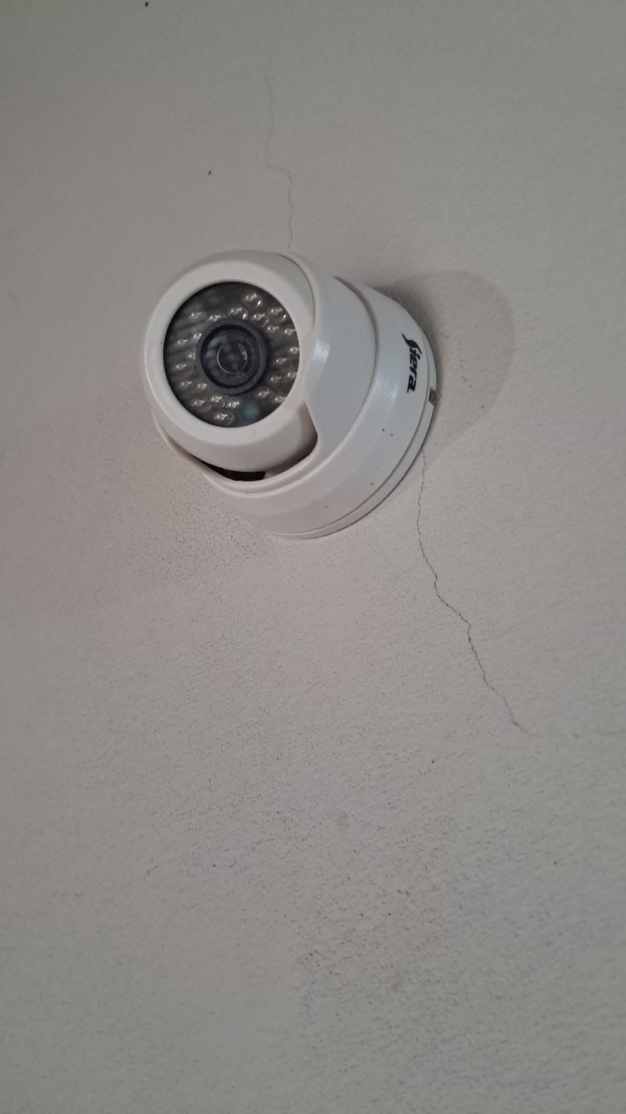 Primer plano de una cámara domo de seguridad instalada en una pared
