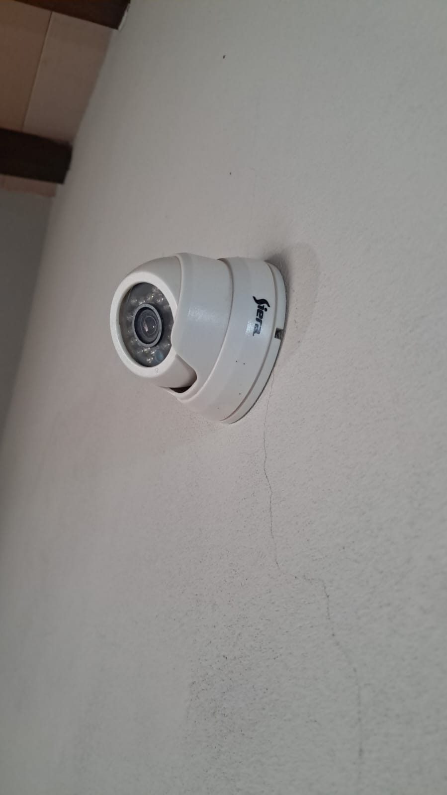 Cámara domo de seguridad instalada en la parte alta de una pared