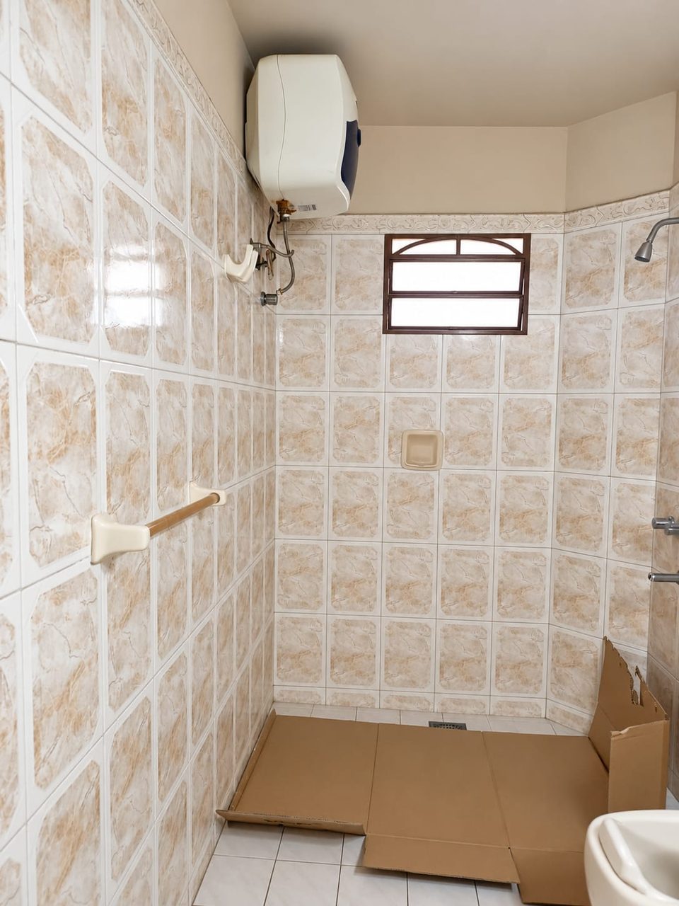 Baño con el termocalefón viejo instalado en la pared, antes del cambio