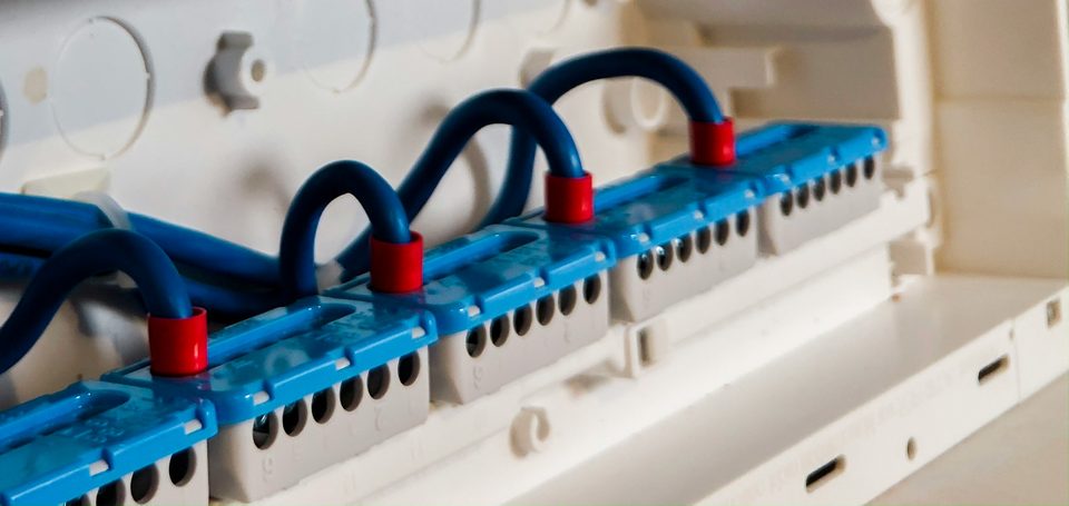 Borneras con puentes de cable azul dentro de un tablero eléctrico