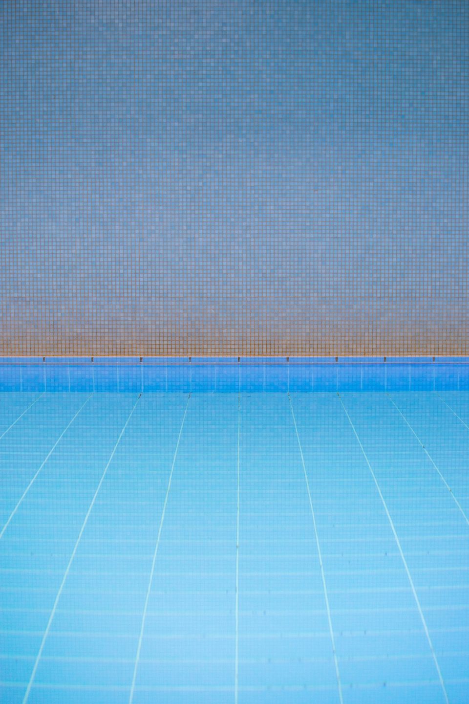 Piscina vacía con revestimiento de venecitas celestes