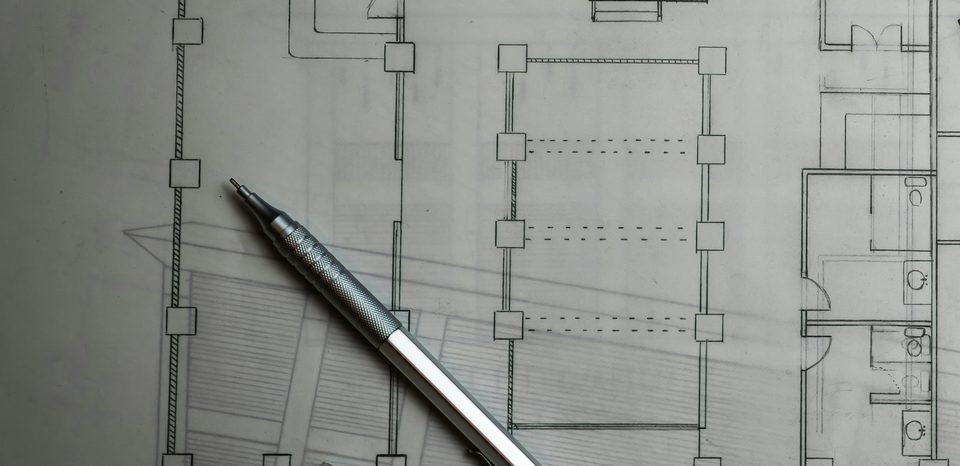 Planos de arquitectura con un portaminas sobre la mesa de trabajo